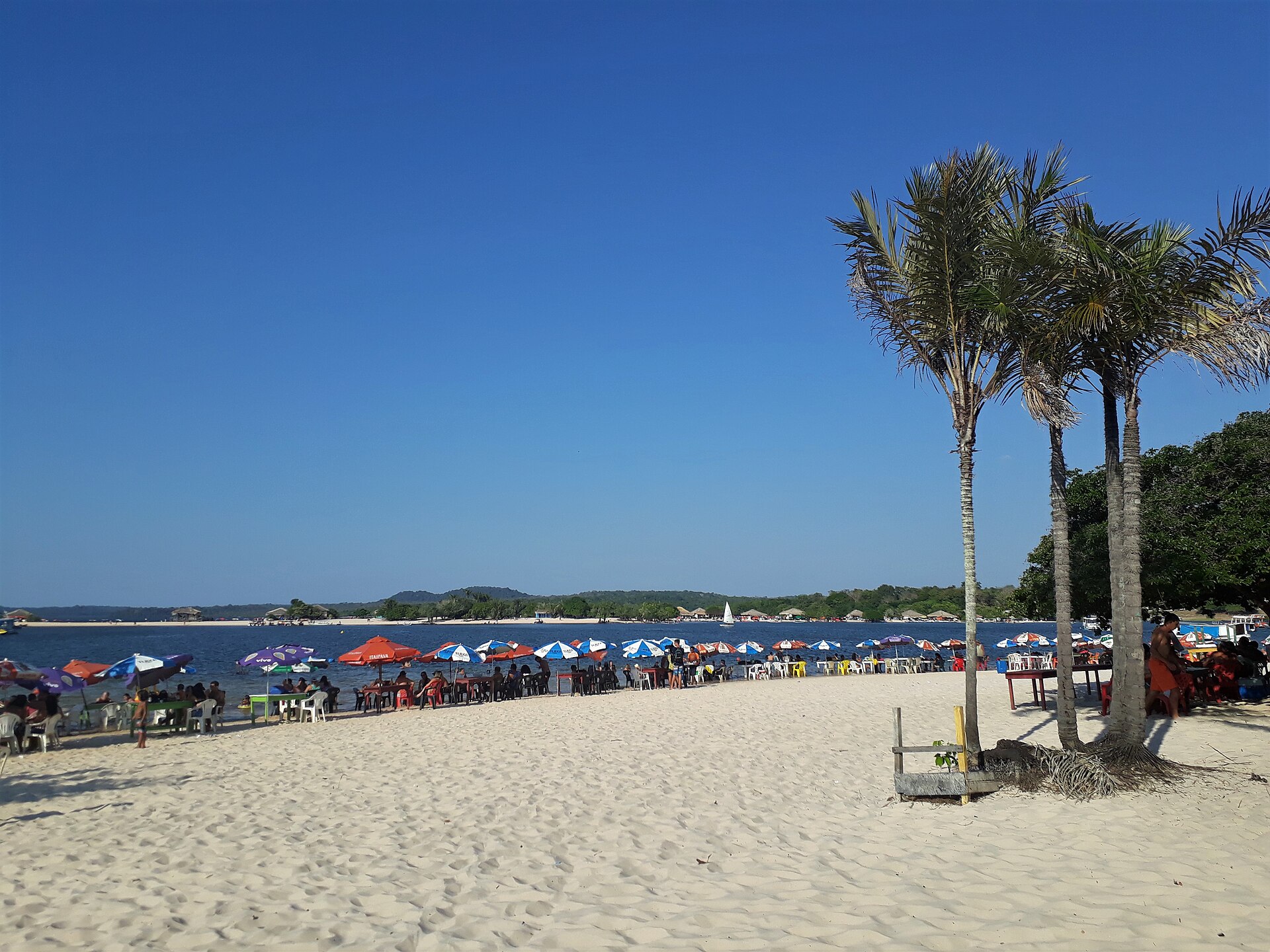 Praia de areia branca com guarda-sóis coloridos em Alter do Chão, no Rio Tapajós