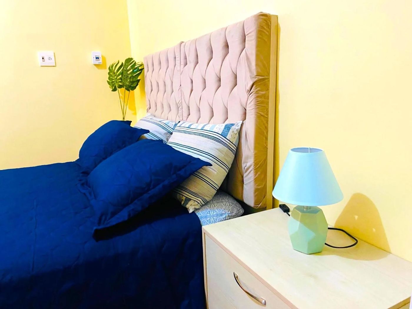 Quarto de casal do Hotel na Orla com cama box, cabeceira estofada e abajur
