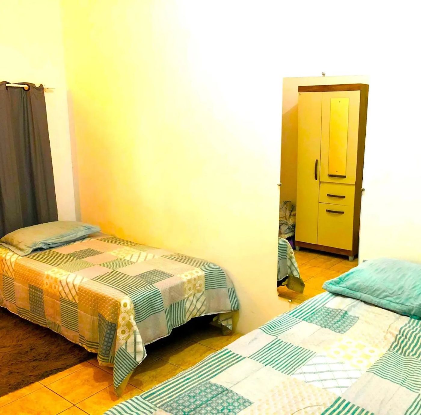 Quarto quádruplo com duas camas de solteiro e armário amarelo