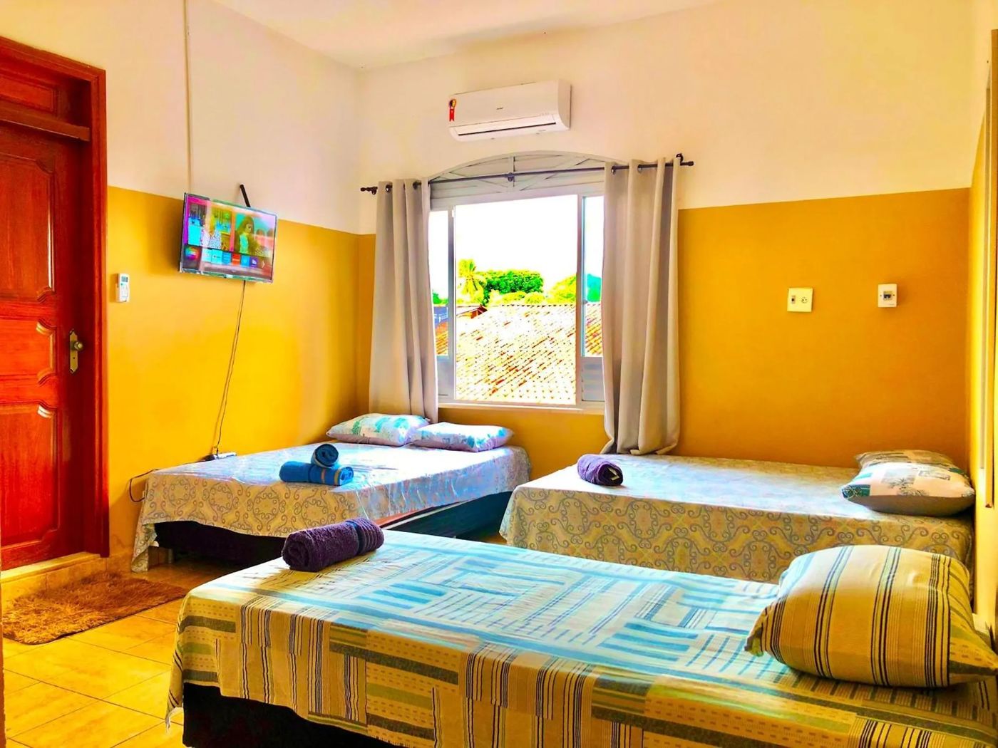 Quarto triplo com três camas de solteiro, ar-condicionado e janela ampla