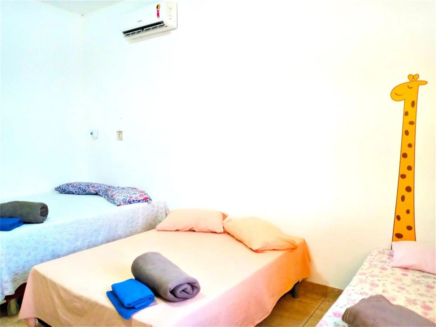 Quarto triplo com camas de solteiro e enxoval limpo dobrado